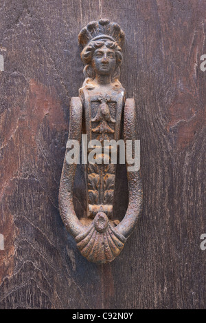 Un classico porta respingente in una donna di forma, arrugginiti e alterò su una porta a Panicale, Italia. Foto Stock