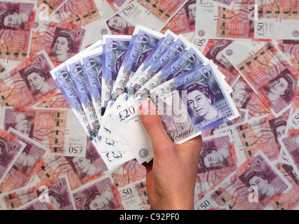 Mano piena di nuovo £20 venti pound note sullo sfondo di £50 cinquanta pound banconote Foto Stock