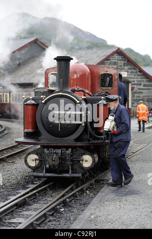 Driver del treno di attaccare la lampada a doppio fairlie locomotiva a vapore Dafydd Lloyd George stazione porthmadog north Wales UK Foto Stock