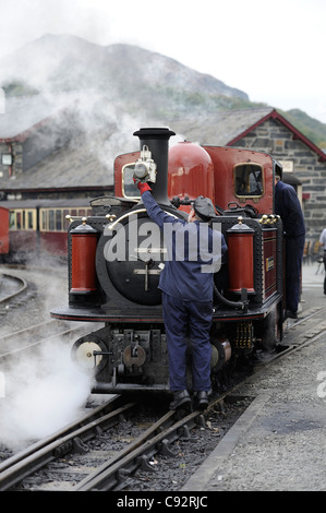 Driver del treno di attaccare la lampada a doppio fairlie locomotiva a vapore Dafydd Lloyd George stazione porthmadog north Wales UK Foto Stock