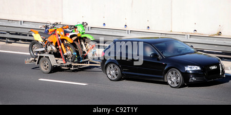 Trasporto auto veicolo di traino rimorchio caricato con due off road Motorcycle Sport bikes percorrendo l autostrada M25, Essex England Regno Unito Foto Stock