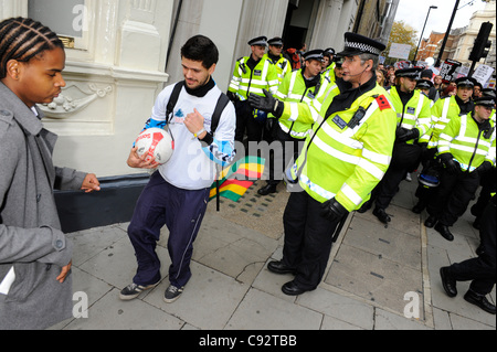 Un manifestante a giocare il gioco del calcio è il biasimo da parte di un ufficiale di polizia durante la protesta studentesca marzo contro sorge in tasse e contributi e finanziamenti per il settore dell'istruzione - Shaftesbury Avenue, Londra, Regno Unito. 9 novembre 2011. Foto: GRAHAM M. Lawrence. Foto Stock