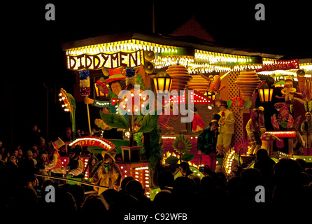 Galleggianti illuminata di notte con musica durante il bridgwater stagione di carnevale con gli spettatori che fiancheggiano le strade Foto Stock