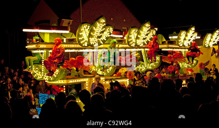 Galleggianti illuminata di notte con musica durante il bridgwater stagione di carnevale con gli spettatori che fiancheggiano le strade Foto Stock