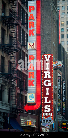 Insegne luminose per Virgils barbecue e un garage per il parcheggio in Times Square a New York Foto Stock