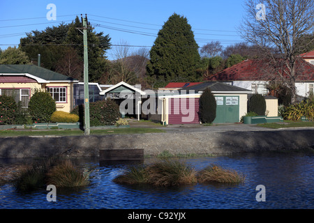 Vista generale mostra quake-case danneggiate attraverso il fiume Avon che attraversa il borgo di Avondale,Christchurch, Nuova Zelanda Foto Stock