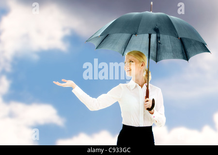 Felice imprenditrice sotto ombrello aperto stretching il suo braccio Foto Stock