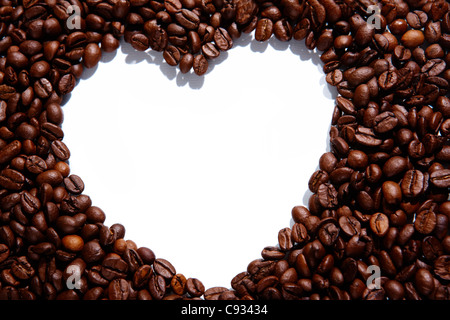 Immagine di chicchi di caffè formando la forma di cuore su sfondo bianco Foto Stock