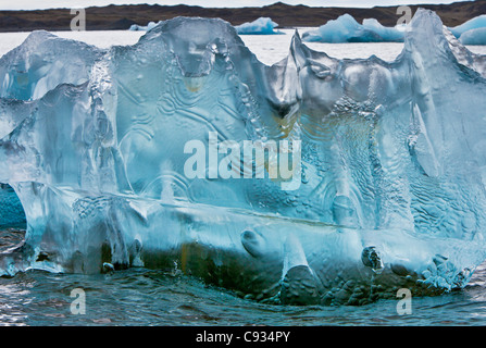 Un grosso blocco di ghiaccio scolpito galleggiante sulla laguna di Jokulsarlon. Foto Stock