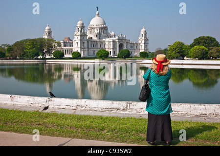 Situato in un rigoglioso parco, il magnifico Victoria Memorial Building con il suo marmo bianco cupole. Foto Stock