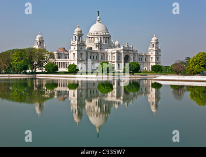 Situato in un rigoglioso parco, il magnifico Victoria Memorial Building con il suo marmo bianco cupole. Foto Stock