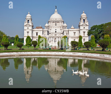 Situato in un rigoglioso parco, il magnifico Victoria Memorial Building con il suo marmo bianco cupole. Foto Stock