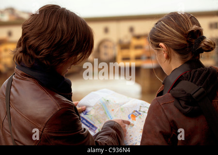 L'Italia, Firenze, Europa occidentale; i turisti la consultazione di una mappa nella parte anteriore del Ponte Vecchio. Signor Foto Stock