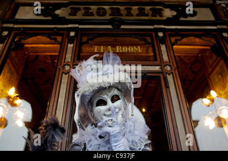 Venezia, Veneto, Italia; una maschera davanti a Florian's Cafe su Piazza San Marco durante il carnevale Foto Stock