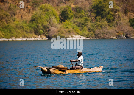 Il Malawi, il Parco Nazionale del Lago Malawi. Fisherman nel suo tradizionale scavato-out canoa Foto Stock