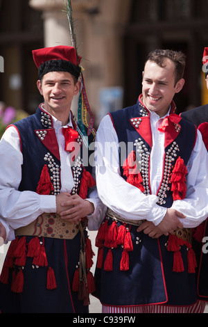 In Polonia, a Cracovia. Lucidare i ragazzi in abito tradizionale preparazione alla danza in piazza del mercato. Foto Stock