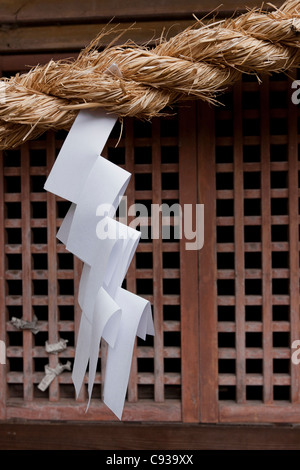 A zig zag, carta shide appesi ad una fune attraverso l'ingresso di un tempio Shintoista a Kanazawa, Ishikawa, Giappone Foto Stock