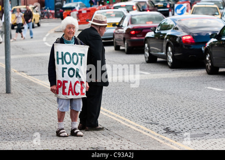 Anziani attivista di pace con 'Hoot per la pace banner', Bristol, Inghilterra Foto Stock