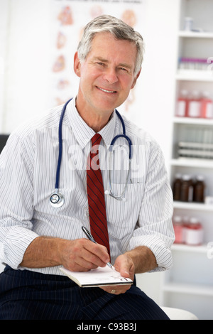 Senior medico prescrizione di scrittura Foto Stock