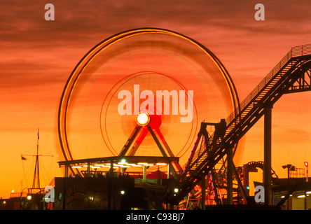 Ruota Gigante a Santa Monica Pier parco divertimenti al tramonto vicino a Los Angeles in California Foto Stock