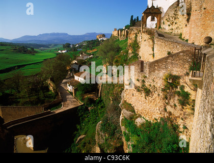 I muri in pietra sotto il borgo collinare di Ronda che si affaccia su campi in provincia di Malaga di Spagna Foto Stock