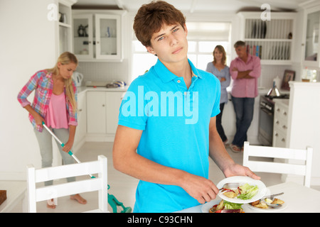 Gli adolescenti a malincuore facendo lavori di casa Foto Stock