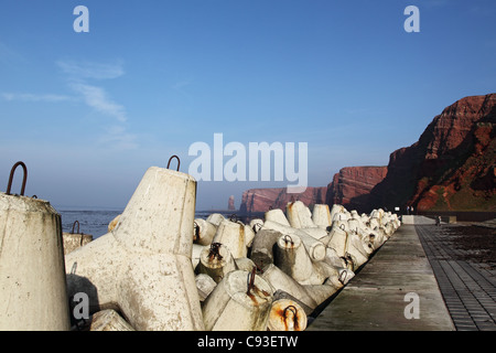 Cliff costa di Helgoland e sullo sfondo la famosa Tall Anna, in primo piano Tetrapods come protezione delle coste. Foto Stock
