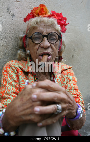 Eccentrica anziana donna cubana Graciela Gonzalez conosciuta anche come Granny Puretta fuma sigaro all'età di 84 anni nel centro storico di l'Avana, Cuba. Foto Stock