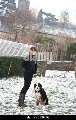 Una donna con il suo Border Collie sheepdog nella neve Foto Stock