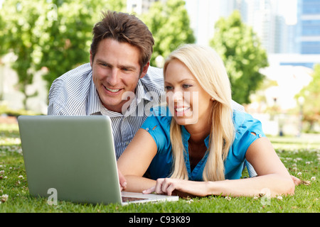 Paio utilizzando laptop nel parco della città Foto Stock