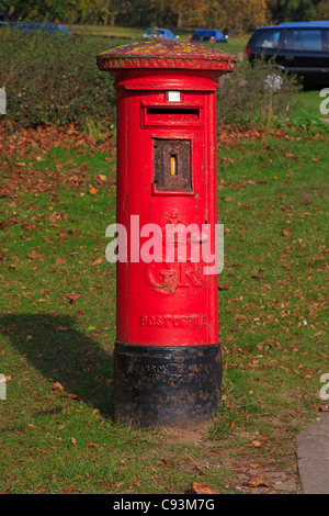 Red pillarbox in una posizione rurale. Caselle di posta dai primi anni del XX secolo e precedenti sono ancora in servizio. Foto Stock