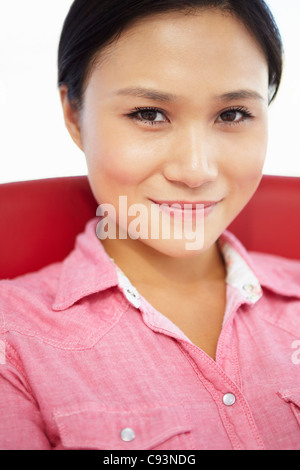 Giovane donna seduta in poltrona Foto Stock