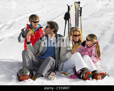 Giovane famiglia condividendo un picnic sulla vacanza sciistica Foto Stock