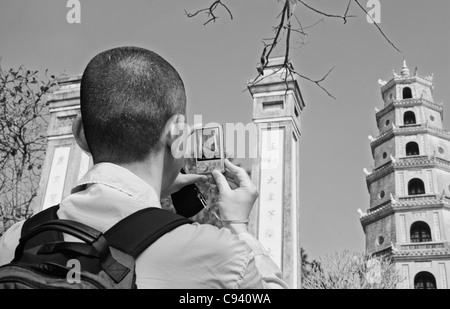 Asia, Vietnam, Tonalità. Tourist fotografare il Thap Phuoc Duyen (fonte di felicità Torre) a Thien Mu (celeste signora Pagoda)... Foto Stock