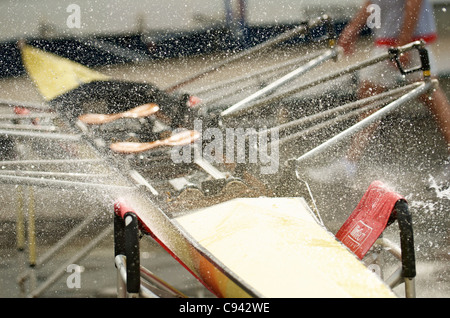 Un vogatore lavando il suo doppio scull canotto. Foto Stock