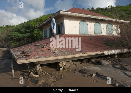 Uomo in piedi sul tetto di tre piani Casa Crowe sepolta da flussi di fango, chiamato lahar, giù la Belham River, Montserrat Foto Stock