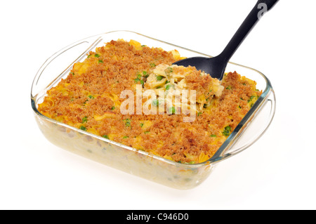 Close up di crema cotta di tonno formaggio a base di noodle casseruola con piselli verdi e rabboccato con pangrattato burroso con cucchiaio in pyrex su sfondo bianco. Foto Stock