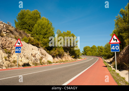 Strada panoramica con rosso corsie di bicicletta in tutta foresta del pino mediterraneo Foto Stock