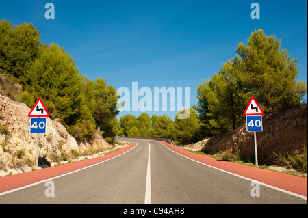 Strada panoramica con rosso corsie di bicicletta in tutta foresta del pino mediterraneo Foto Stock