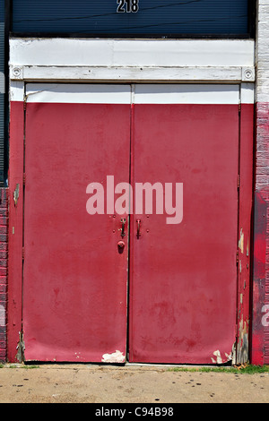 Doppie porte dipinte di rosso con bianco e finiture blu. Foto Stock