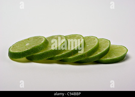 Fettine di lime giacciono su uno sfondo semplice. Foto Stock