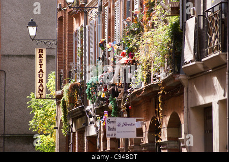 Fiori sul balcone accanto a un ristorante, Toulouse, Haute-Garonne, Midi- Pyréneés, Occitanie, Francia Foto Stock