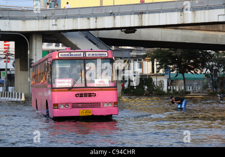 Una unità bus attraverso le acque alluvionali di fronte ad un centro commerciale per lo shopping nel novembre 12, 2011 in ladprao district, Bangkok, Thailandia. Oltre sette dei principali parchi industriali a Bangkok e migliaia di fabbriche sono state chiuse. La Thailandia sta attraversando una delle peggiori inondazioni in oltre 50 anni . Foto Stock