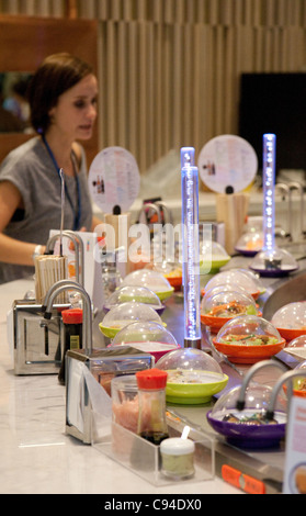 Donna di mangiare sushi, la Yo Sushi bar, il centro commerciale Westfield Stratford London REGNO UNITO Foto Stock