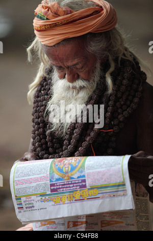 Sadhu Uomo leggendo un giornale Arunachala India del Sud Tamil Nadu India Foto Stock