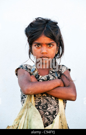 Povero indiano mendicante nomadi ragazza che fissa con bracci ripiegati guardando fiduciosi Foto Stock