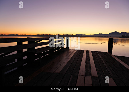 Il molo di legno sul Chiemsee a sunrise, Chiemgau Alta Baviera Germania Foto Stock