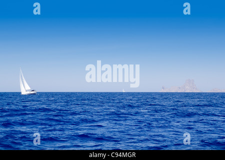 Ibiza Es Vedra e barca a vela in blu mare mediterraneo Foto Stock