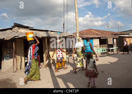 Le donne a piedi attraverso le strade di Temeke, una delle baraccopoli in Dar es Salaam, Tanzania Africa Orientale. Foto Stock