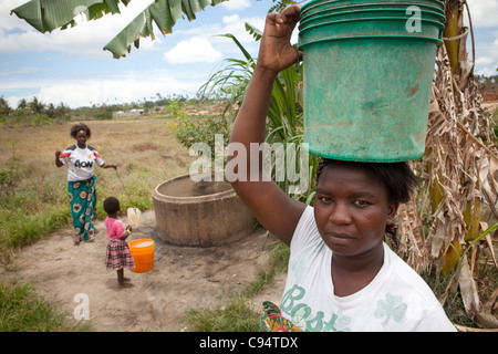 Una donna si erge in una zona rurale bene in un villaggio fuori da Dar es Salaam, Tanzania Africa Orientale. Foto Stock